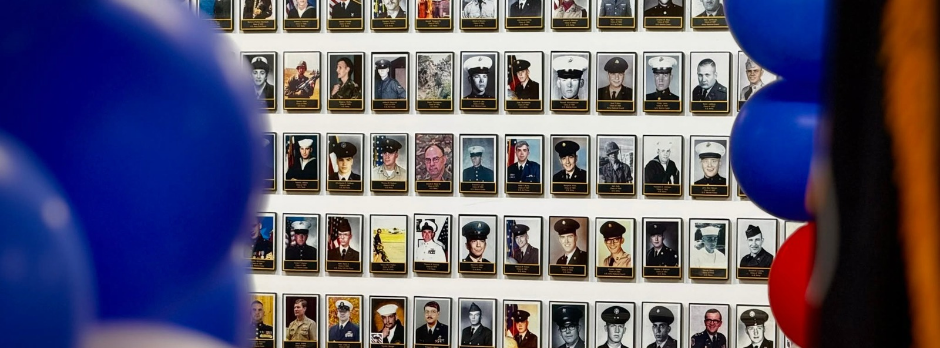 Rows of military service portraits displayed on the Coopersville High School Wall of Honor.