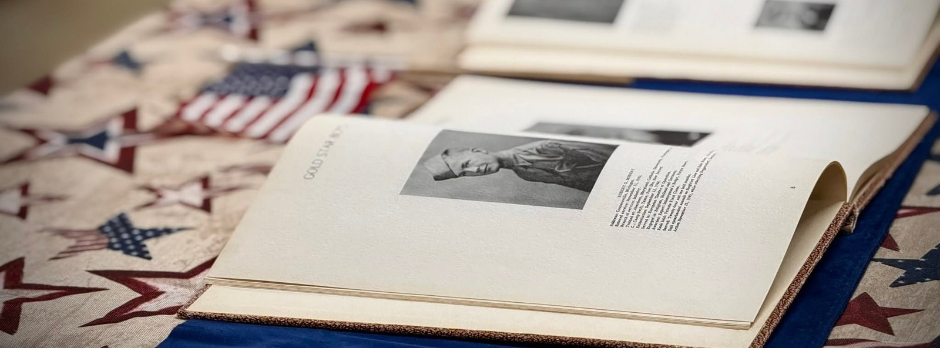 An open historical yearbook featuring a military portrait displayed on a patriotic tablecloth.