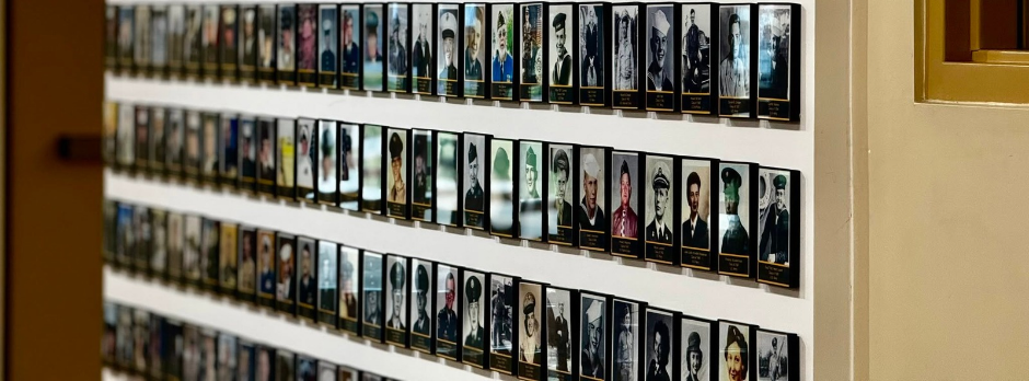 Rows of military service portraits displayed along the Coopersville High School Wall of Honor.